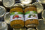 Two jars of spices with labels on a background of metal lids